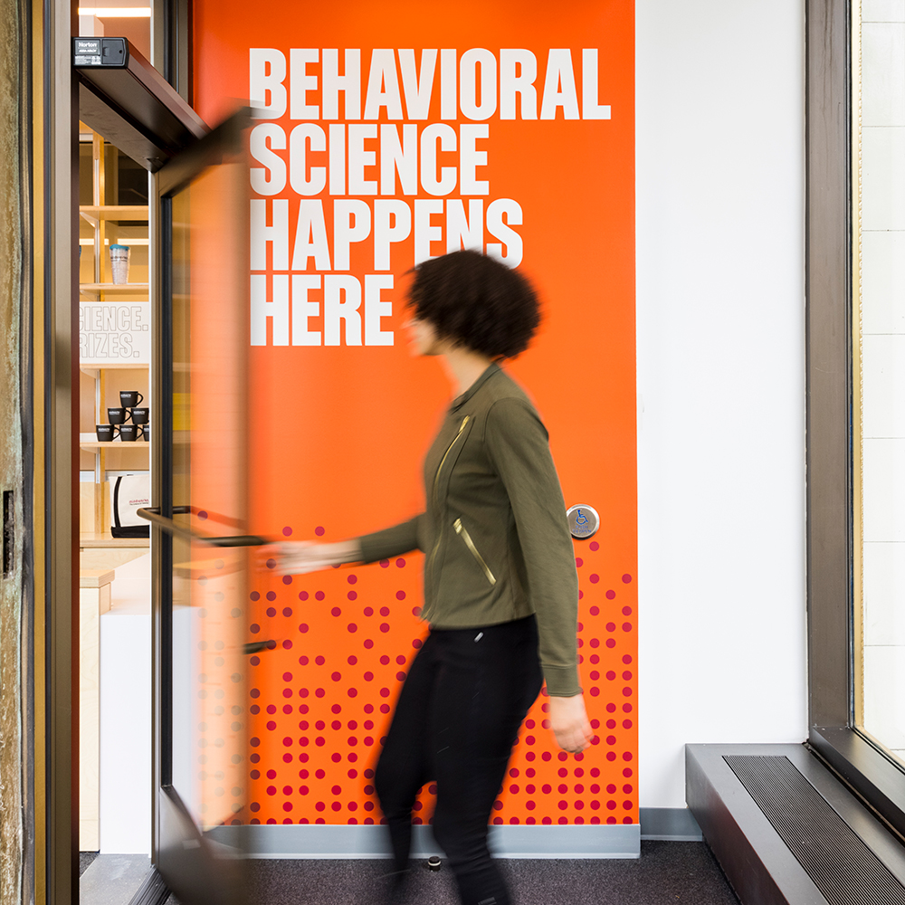 A woman enters Mindworks in front of a wall that says "behavioral science happens here"